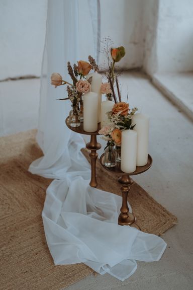 Etagere mit Vasen, Blumen und Blockkerzen darauf