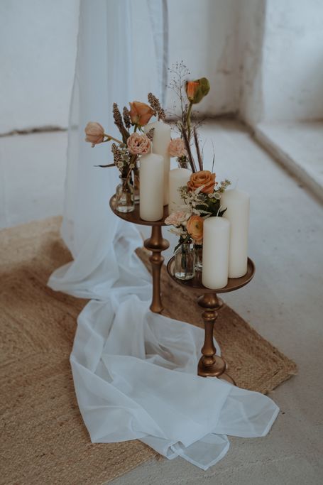 goldene Etagere mit Vasen, Blumen und Kerzen darauf