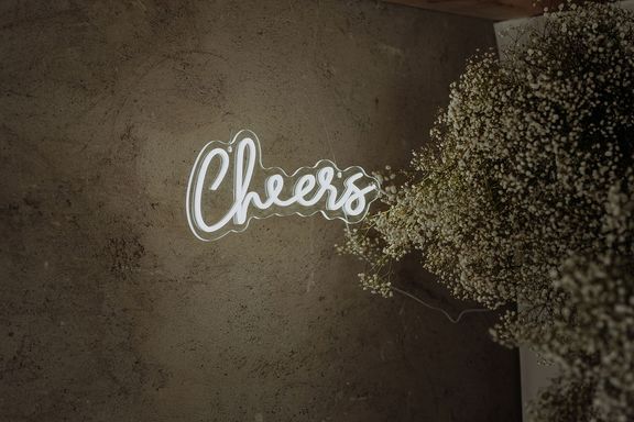 Foto von einem Neon-Leuchtschild mit der Aufschrift "Cheers"